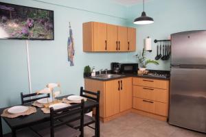 uma cozinha com uma mesa e um frigorífico de aço inoxidável em 212 APARTMENT em Rincon