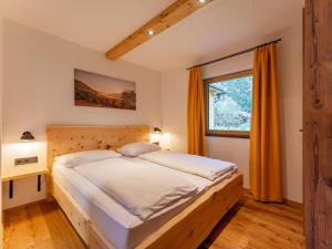 a bedroom with a large bed and a window at AlmApARTment Mauterndorf Pichl 9-3 in Mauterndorf