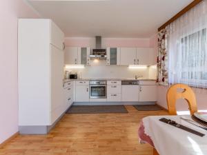 eine Küche mit weißen Schränken und Holzböden in der Unterkunft Schmitzer in Mühldorf
