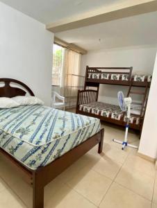 a bedroom with a bed and a fan in it at Jurado, Casa Hospedaje in Tonsupa