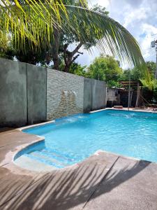 a large blue swimming pool with a brick wall at Ometepe House in Moyogalpa