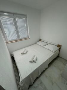ein Schlafzimmer mit einem Bett mit zwei Hausschuhen darauf in der Unterkunft Apartments Arjan2 in Omiš
