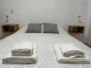 1 dormitorio con 1 cama con toallas en Departamento Hilario en San Rafael
