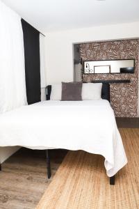 1 dormitorio con 1 cama grande con sábanas blancas en Private Rooms in Duplex Home 4 Bath FQ Beds 1-3ppl en San Juan