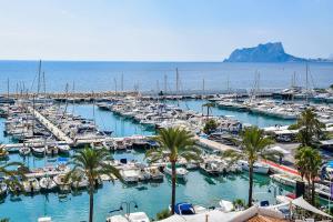 a bunch of boats docked in a marina with palm trees at Casa Mila in Moraira