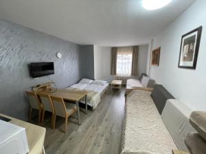 Zimmer mit 2 Betten, einem Tisch und einem Sofa in der Unterkunft Apartments Konaci Kopaonik in Kopaonik