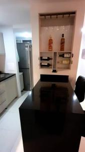 Il comprend une cuisine équipée d'un comptoir noir et d'un réfrigérateur. dans l'établissement Apartamento en Villavicencio, à Villavicencio