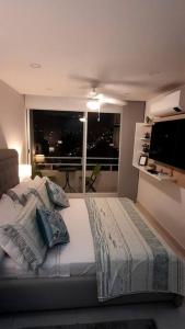 - une chambre avec un grand lit et une fenêtre dans l'établissement Apartamento en Villavicencio, à Villavicencio
