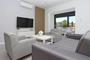 a living room with a couch and a tv at Holiday house with a swimming pool Senj - 21661 in Senj