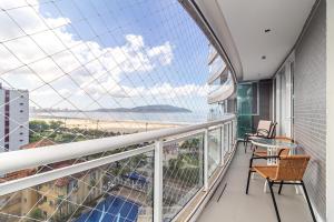 a balcony with a table and chairs and a view of the ocean at AP OCEAN UNLIMITED - Vista panorâmica da praia de Santos no Unlimited in Santos