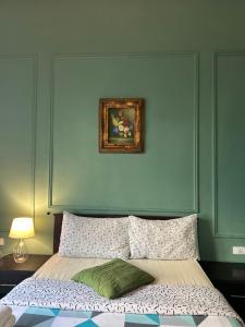 a bedroom with a bed with a painting above it at City Citadel Hotel,Amman in Amman