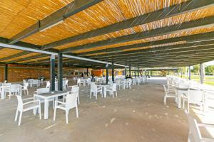 a patio with white tables and chairs under a wooden ceiling at Paradise Town Villa Legend in Belek