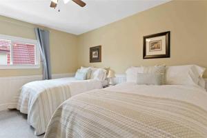 two white beds in a room with a window at Perfection near the River - 4 Bedroom Villa Complimentary Breakfast Delivered Daily to the Rental in Niagara Falls