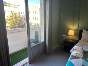 1 dormitorio con 1 cama y puerta corredera de cristal en City Citadel Hotel,Amman, en Amán