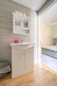 a bathroom with a white sink and a bed at The Blue House holiday home in Egremont