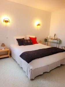 Mortagne-sur-GirondeにあるLogis de La Garenneのベッドルーム1室(大型ベッド1台、赤と黒の枕付)