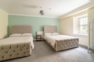 two beds in a room with two bedsitures at The Blue House holiday home in Egremont