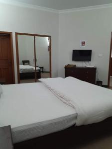 カラチにあるKarachi Airport Hotelsの鏡付きの客室内の大きな白いベッド
