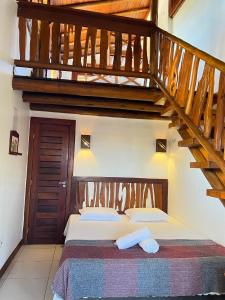 1 dormitorio con 1 cama y escalera de madera en Casa grande 12 pessoas Rio das onças, en Fortim