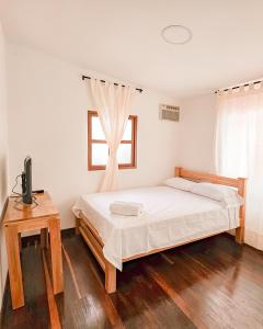 a bedroom with a bed and a table and a window at Hotel Villa Santa María in Santa Fe de Antioquia
