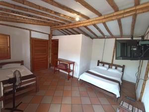 a room with two beds and a tv in it at Hotel Terrazas de la Candelaria in San Gil