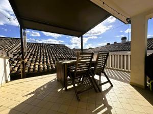 un tavolo e due sedie su un balcone con ombrellone di [Stunning Terrace] Chill in Fano a Fano