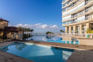 a large swimming pool next to a tall building at AP OCEAN UNLIMITED - Vista panorâmica da praia de Santos no Unlimited in Santos
