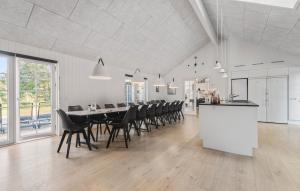 a dining room with a long table and chairs at Amazing Home In Blåvand With Sauna in Blåvand +36 photos