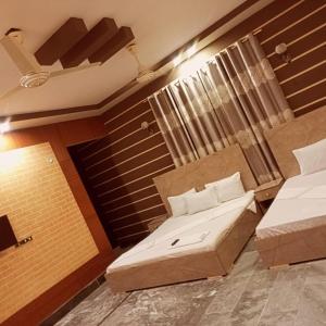 カラチにあるKarachi Airport Hotelsのベッド2台と窓が備わる客室です。