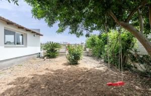 un jardín con un árbol y una pala roja en Amazing Home In Santa Maria Del Focall, en Santa Maria del Focallo