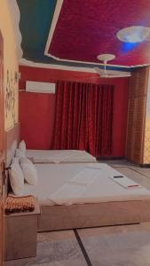 カラチにあるKarachi Airport Hotelsのベッドルーム1室(赤いカーテン付きの大型ベッド1台付)