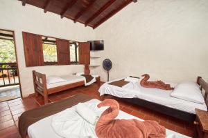 Zimmer mit 3 Betten und einem Elefanten auf dem Boden in der Unterkunft Hotel Terrazas de la Candelaria in San Gil