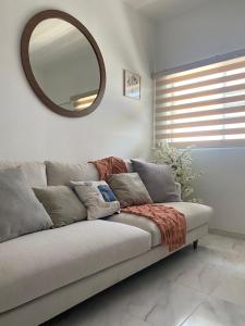 a couch in a living room with a mirror at Departamento exclusivo en Puerto Vallarta in Ixtapa