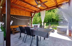 a patio with a table and chairs and a tub at 2 Bedroom Amazing Home In Donja Lomnica in Donja Lomnica