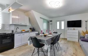 eine Küche und ein Esszimmer mit einem Tisch und Stühlen in der Unterkunft Amazing Home In Donja Lomnica With Kitchen in Donja Lomnica
