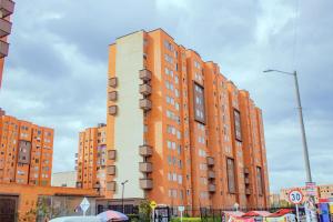 un grand bâtiment en briques rouges dans une ville dans l'établissement Acogedor Apartamento en zona residencial con vista a la ciudad Wi-Fi 350 Mbps, à Bogotá