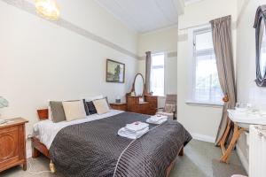a bedroom with a bed and a sink at Braemar House B&B and YHA Hostel in Whanganui