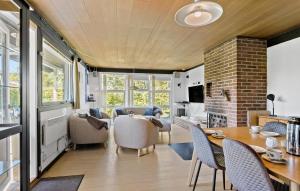 eine Küche und ein Wohnzimmer mit einem Tisch und Stühlen in der Unterkunft Amazing Home In Svendborg With Kitchen in Vemmenæs