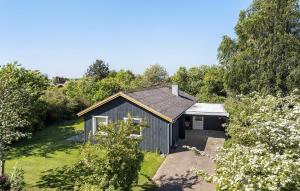 a small shed in a garden with trees at Amazing Home In Svendborg With Kitchen in Vemmenæs