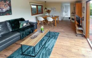 a living room with a black couch and a table at Pet Friendly Stacaravan In Tzummarum in Tzummarum