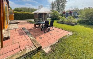 a patio with a table and chairs and an umbrella at Pet Friendly Stacaravan In Tzummarum in Tzummarum +11 photos