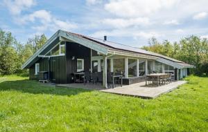 a black house with a wooden deck in a field at Nice Home In Sydals With Wifi in Høruphav +21 photos