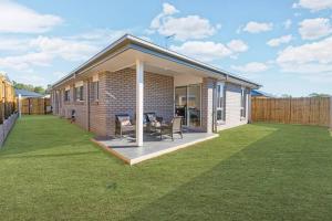 a small house with a lawn in front of it at Amazing 4 rooms House near SpringField Lakes in Greenbank
