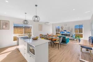 a kitchen and living room with a table and a couch at Amazing 4 rooms House near SpringField Lakes in Greenbank