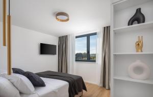 a white bedroom with a bed and a window at Lovely Apartment In Rogoznica With Wifi in Rogoznica
