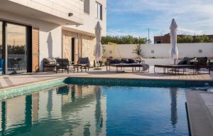 a swimming pool in front of a house at Lovely Apartment In Rogoznica With Wifi in Rogoznica +10 photos