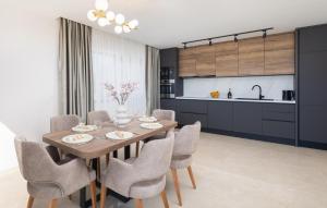 a kitchen and dining room with a wooden table and chairs at Lovely Apartment In Rogoznica With Wifi in Rogoznica