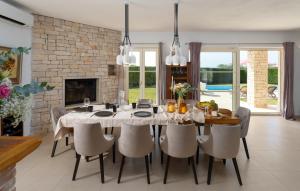 une salle à manger avec une table et des chaises et une cheminée dans l'établissement Villa Bincila Labinci, à Poreč