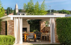 - un pavillon avec une table et des chaises sur la terrasse dans l'établissement Villa Bincila Labinci, à Poreč