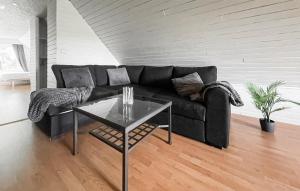 a living room with a black couch and a table at Cozy Apartment In ngelhom With Wifi in Ängelholm